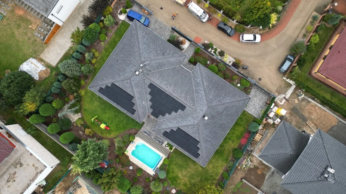 Letecký pohled na dům, zahradu s bazénem a fotovoltaiku na střeše